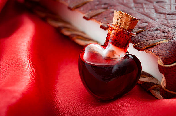 A bottle of Love Spells Potion leaning on a red book of magic love spells